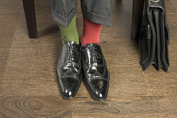 Schuhe eines Wirtschaftsprüfers mit unterschiedlich gefärbten Socken