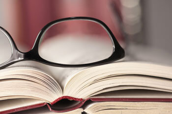 Eine Brille in Nahaufnahme liegt auf einem Buch